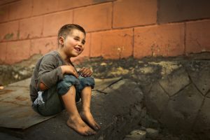 alone sad child playing on a street